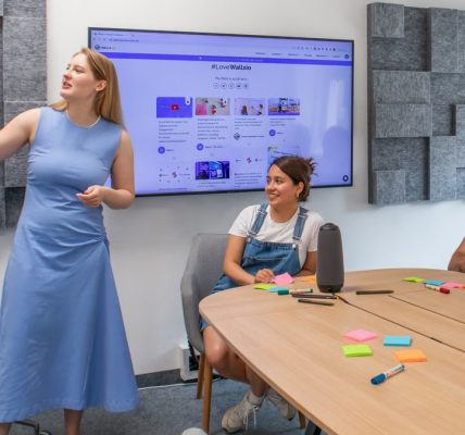 Three colleagues discussing ideas during a team meeting in a conference room.